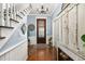 Charming foyer with refinished wood floors, chandelier, staircase and decorative cabinet at 525 W Blue Springs Ave, Orange City, FL 32763