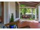 Inviting front porch with a charming swing and painted red floors for relaxing outdoors at 525 W Blue Springs Ave, Orange City, FL 32763