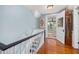 Upper hallway with wood floors and view to staircase landing at 525 W Blue Springs Ave, Orange City, FL 32763