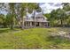 Charming two-story home with a large front porch and lush greenery, creating a welcoming and picturesque setting at 525 W Blue Springs Ave, Orange City, FL 32763