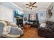 Cozy living room with hardwood floors, a fireplace, a ceiling fan, and a large leather sofa at 525 W Blue Springs Ave, Orange City, FL 32763