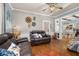 Spacious living room with wood floors, decorative wall art, and views into the dining room at 525 W Blue Springs Ave, Orange City, FL 32763