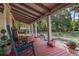Inviting front porch with rocking chairs, greenery, and lanterns, creating a cozy outdoor living space at 525 W Blue Springs Ave, Orange City, FL 32763