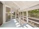 Enclosed porch featuring ample windows, white railings, and a light blue floor, perfect for enjoying the outdoors at 525 W Blue Springs Ave, Orange City, FL 32763