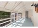 Sunlit enclosed porch boasts white railings and a light blue floor, offering a serene space with ample windows at 525 W Blue Springs Ave, Orange City, FL 32763
