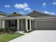 Charming single-story home featuring a two-car garage, manicured lawn, and covered front entry at 537 S Andrea Cir, Haines City, FL 33844