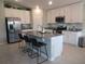 Modern kitchen with stainless steel appliances, center island with seating, and tiled backsplash at 537 S Andrea Cir, Haines City, FL 33844