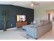 Stylish living room with eye catching accent wall, plush gray sofa, and modern decor at 537 S Andrea Cir, Haines City, FL 33844