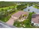 Stunning aerial view of a home with a tile roof, lush landscaping, and a peaceful lake in the background at 561 Tapatio Ln, Kissimmee, FL 34759