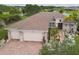 Aerial view of a single-Gathering home with tile roof, three-car garage, and meticulously maintained landscaping at 561 Tapatio Ln, Kissimmee, FL 34759