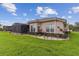 Picture of the backyard, showcasing a well-manicured lawn, tasteful landscaping, and a screened-in patio at 561 Tapatio Ln, Kissimmee, FL 34759