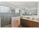 Well-lit bathroom features dual sinks, marble counters, wood cabinets, and a seamless glass shower at 561 Tapatio Ln, Kissimmee, FL 34759