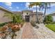 Attractive home with a brick walkway, stone accents, vibrant landscaping, and towering palm trees at 561 Tapatio Ln, Kissimmee, FL 34759