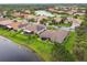 Aerial view featuring a home with a screened lanai, lush landscaping and a nearby lake at 561 Tapatio Ln, Kissimmee, FL 34759