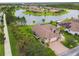 Aerial view of a lovely home with a brick driveway, lush landscaping, and a serene lake at 561 Tapatio Ln, Kissimmee, FL 34759