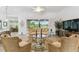 Inviting living room with cozy seating, tile floors, and a beautiful view of the lake and garden at 561 Tapatio Ln, Kissimmee, FL 34759