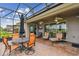 Relax and unwind on the screened patio with a dining set, cozy chairs, and views of the backyard at 561 Tapatio Ln, Kissimmee, FL 34759