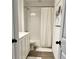 Clean bathroom with white tile, a tub-shower combo, and wood-look flooring at 5725 Iron Brand Rd, St Cloud, FL 34771