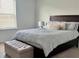 Charming bedroom featuring a well-dressed bed, natural light from a large window, and a cozy ottoman at 5725 Iron Brand Rd, St Cloud, FL 34771
