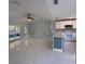 Bright living space featuring modern flooring, a vaulted ceiling with fan, and a seamless flow into the kitchen at 6489 Creation St, St Cloud, FL 34771