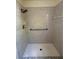Walk-in shower featuring stylish tile, a shower head, and a grab bar for accessibility at 6489 Creation St, St Cloud, FL 34771