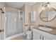 Bathroom featuring a walk-in shower and a vanity with a round mirror at 710 Carlton Ave, Lake Wales, FL 33853