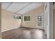 Bedroom featuring wood floors, a door to the exterior and two windows at 710 Carlton Ave, Lake Wales, FL 33853