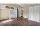 Bedroom with wood floors, built-in storage, and closet with bifold doors at 710 Carlton Ave, Lake Wales, FL 33853