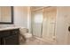 Bathroom featuring a walk-in shower with glass doors, granite countertop, toilet, and dark vanity at 8517 Bay Lilly Loop, Kissimmee, FL 34747