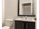 Bathroom featuring a dark vanity with granite countertops, toilet, and mirror at 8517 Bay Lilly Loop, Kissimmee, FL 34747
