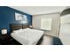 Modern bedroom featuring a king-sized bed, blue accent wall, and contemporary decor at 8517 Bay Lilly Loop, Kissimmee, FL 34747