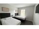 Bright bedroom with two twin beds, neutral walls, and minimalist decor at 8517 Bay Lilly Loop, Kissimmee, FL 34747