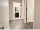 Hallway with laminate flooring, leading to a bathroom with a dark vanity at 8517 Bay Lilly Loop, Kissimmee, FL 34747