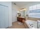 Bathroom with double sinks, a jacuzzi tub, and cherry wood cabinets at 8835 Abbey Leaf Ln, Orlando, FL 32827