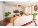 Bright living room with a white sofa, television, and indoor plants at 8835 Abbey Leaf Ln, Orlando, FL 32827