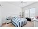 Bright bedroom featuring a striped comforter, a ceiling fan and two large windows at 1231 Wright Cir # 1213, Celebration, FL 34747