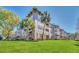 Three-story condo building featuring palm trees and well-maintained landscaping at 1231 Wright Cir # 1213, Celebration, FL 34747