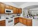 Functional kitchen featuring white appliances and wood cabinets at 1231 Wright Cir # 1213, Celebration, FL 34747