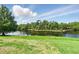 Scenic lake view with lush green trees and a grassy shoreline under a blue sky at 1231 Wright Cir # 1213, Celebration, FL 34747
