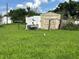View of the backyard with a shed and some debris at 127 Alabama Ave, St Cloud, FL 34769