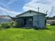 Exterior shot of a single-story home with a covered porch and overgrown lawn at 127 Alabama Ave, St Cloud, FL 34769