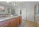 Bathroom featuring double sinks, granite counters, tiled floors, and walk-in shower at 1394 Palmetto Dunes St, Champions Gate, FL 33896