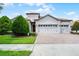 Charming single-story home with a tile roof, three-car garage and manicured landscaping at 1394 Palmetto Dunes St, Champions Gate, FL 33896