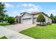 Elegant home featuring a three-car garage, lush landscaping, and a paved driveway, showcasing curb appeal at 1394 Palmetto Dunes St, Champions Gate, FL 33896