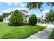 Beautifully landscaped front yard with manicured lawns and mature trees, offering a serene and inviting atmosphere at 1394 Palmetto Dunes St, Champions Gate, FL 33896