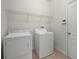 Functional laundry room with appliances, wire shelving, tile floors, and white door at 1394 Palmetto Dunes St, Champions Gate, FL 33896