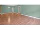 Open-concept living room featuring wood flooring, light fixtures, and neutral green color palette at 1394 Palmetto Dunes St, Champions Gate, FL 33896