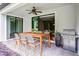 Relaxing outdoor patio features dining table, ceiling fan, and stainless steel grill at 1394 Palmetto Dunes St, Champions Gate, FL 33896