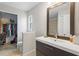 Modern bathroom featuring a dark vanity, toilet, walk-in closet, and walk-in shower at 142 Ethan Ave, Davenport, FL 33897
