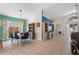 Dining room connected to living room with blue chairs, wooden table and wicker lighting fixture at 142 Ethan Ave, Davenport, FL 33897
